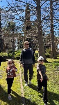 Pedro Alfonso camina por un parque arbolado acompañado por dos de sus hijos en una jornada al aire libre.