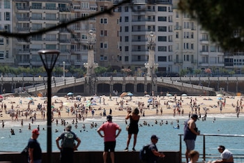 Bañistas disfrutan de un día veraniego en la bahía de la Concha de San Sebastián, a 27 de mayo de 2026. (EFE/Juan Herrero)