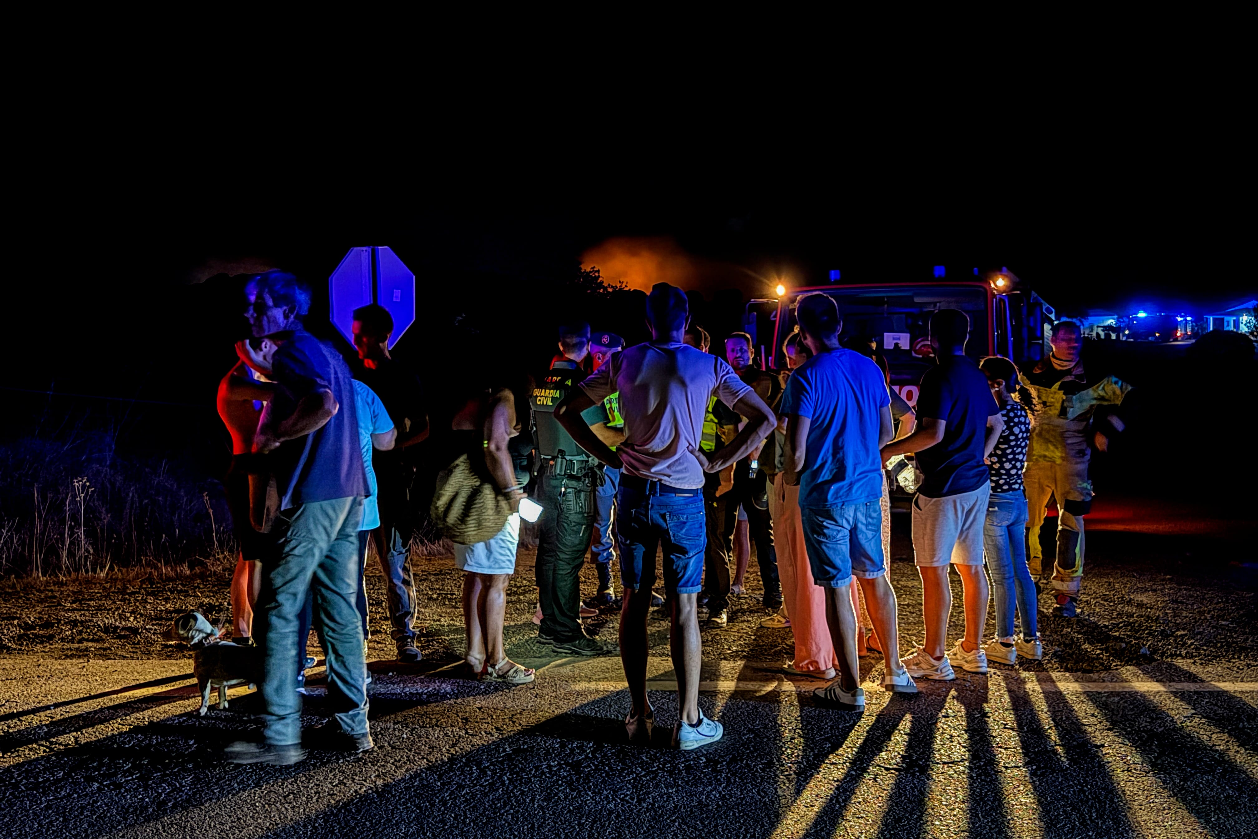 Varias personas observan las lamas del Incendio forestal declarado ayer tarde en el paraje Raboconejo de Niebla (Huelva). (EFE/David Arjona)