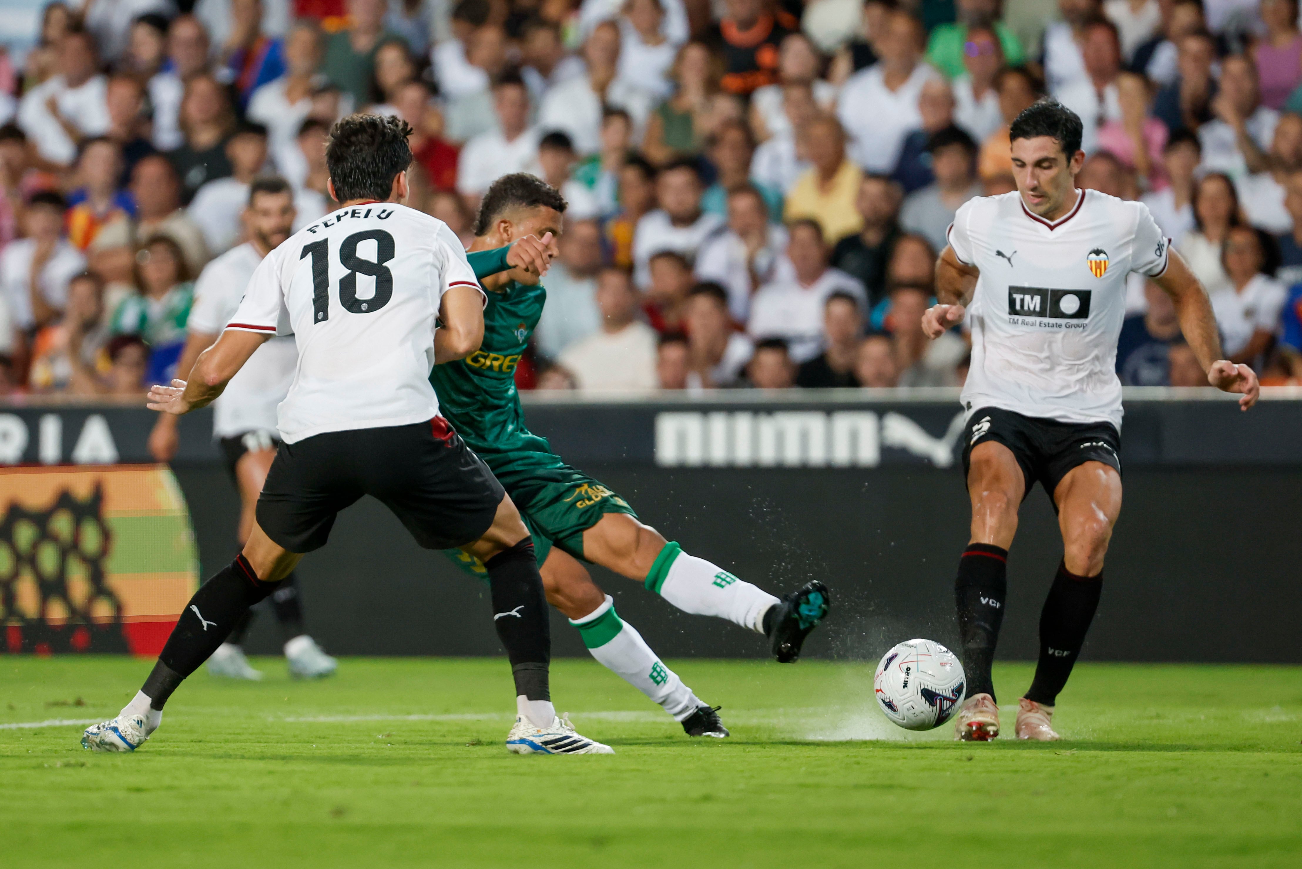 VALENCIA, 25/08/2026.- El centrocampista colombiano del Real Betis Nelson Deossa (c) dispara ante Pepelu (i), del Valencia CF, durante el partido de la primera jornada de LaLiga que Valencia CF y Real Betis disputan este martes en Mestalla-crédito Manuel Bruque/EFE