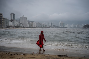 Un salvavidas recorre una playa vacía por el oleaje provocado por el paso del huracán Polo este miércoles, que ha originado la suspensión de clases en las escuelas, compras de pánico y el cierre del puerto, mientras las autoridades han solicitado a las personas que no salgan a las calles ante los fuertes vientos y lluvias, en el balneario de Acapulco (México). EFE/ David Guzmán