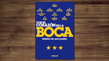 Una imagen de un libro titulado "Con el Corazón en la Boca" con letras amarillas sobre fondo azul, listando 11 autores, sobre una mesa de madera