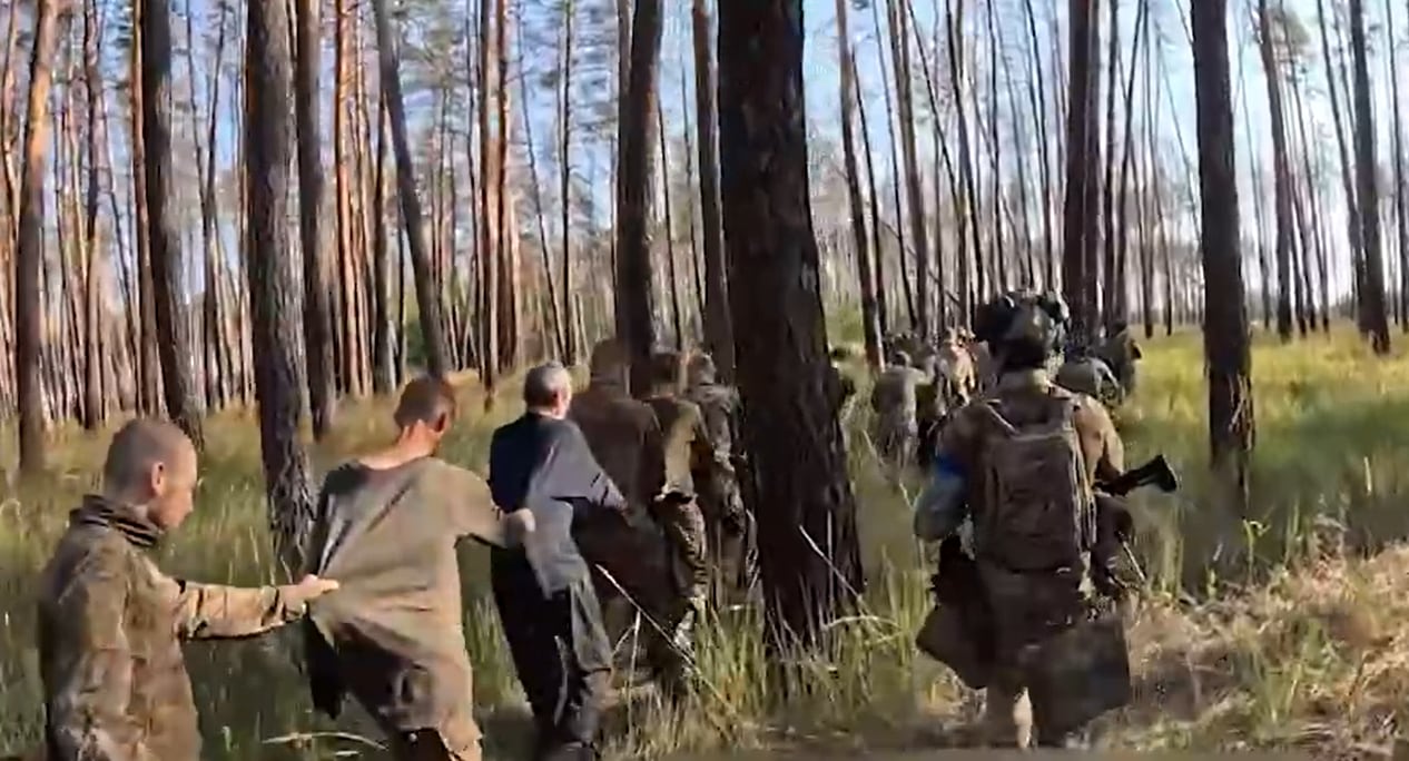 Fotograma del video: militares prisioneros avanzan en columna por un bosque tras rendirse ante unidades del Tercer Cuerpo de Ejército de las Fuerzas Armadas de Ucrania.