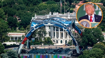 Vista aérea de la Casa Blanca con un escenario grande con temática estadounidense en construcción en el jardín. En la esquina superior derecha, foto circular de Donald Trump sonriendo.