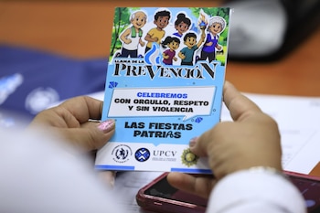 Unas manos sostienen un folleto ilustrado con el texto «Llama de la Prevención» y logotipos institucionales