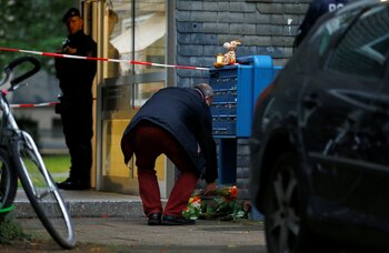 Un hombre deposita flores a