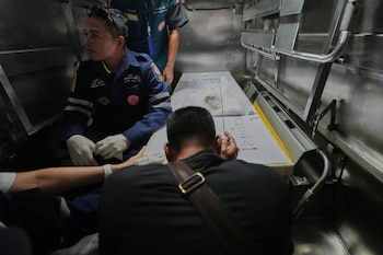Un familiar rinde homenaje al cuerpo de una víctima del incendio en un hospital policial de Bangkok (archivo/AP Foto/Sakchai Lalit)