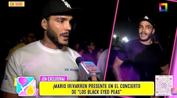 Un hombre con camiseta blanca y gorra negra habla ante un micrófono de televisión en una transmisión nocturna