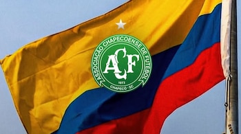 El escudo de Chapecoense, equipo del fútbol brasileño, y la bandera de Colombia - crédito Chapecoense