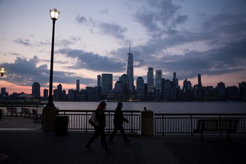 Transeúntes caminan frente al skyline