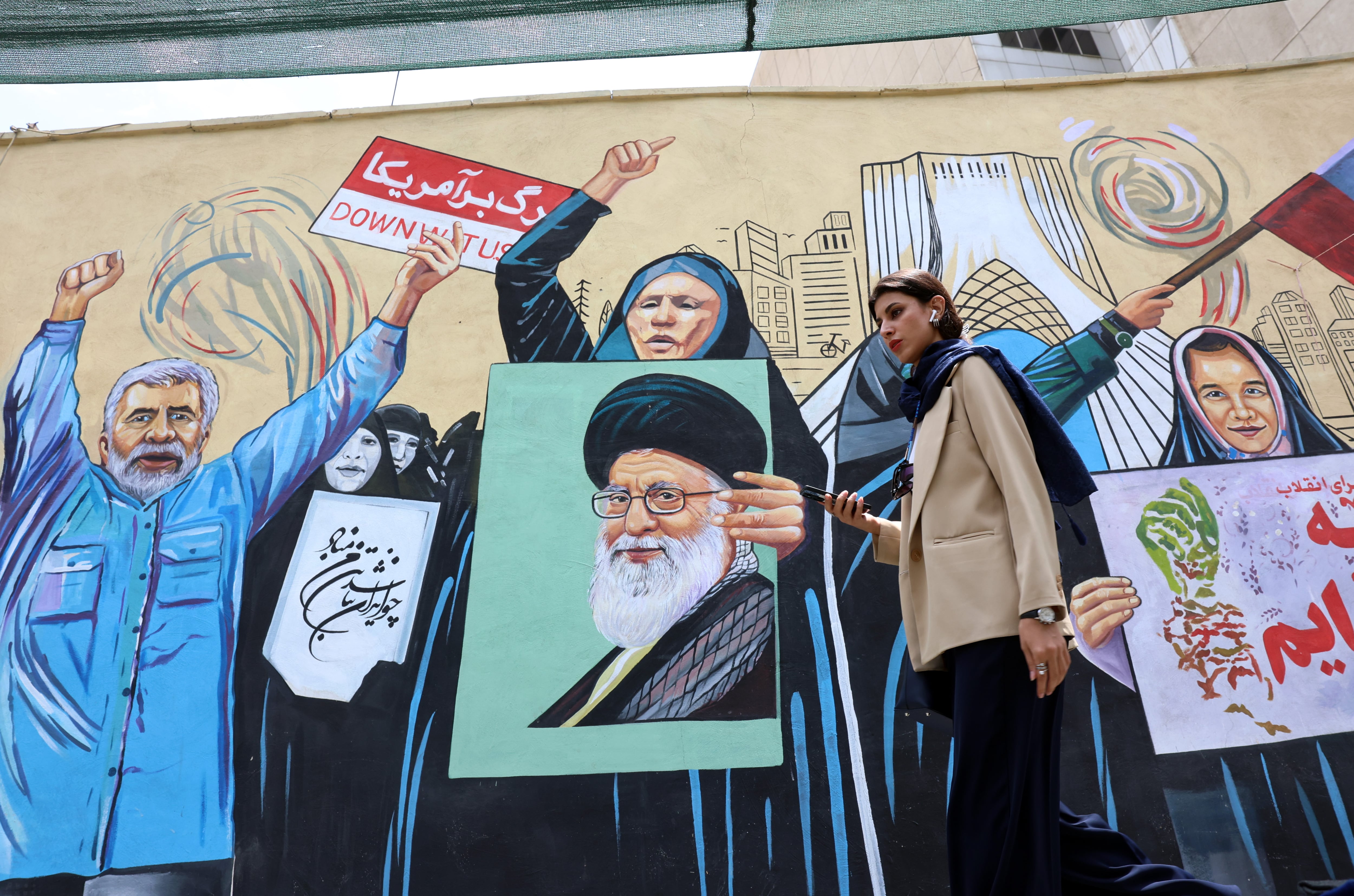 Una mujer camina junto a una pintada antiestadounidense en una calle de Teherán, Irán, el 20 de julio de 2026. (EFE/Abedin Taherkenareh)