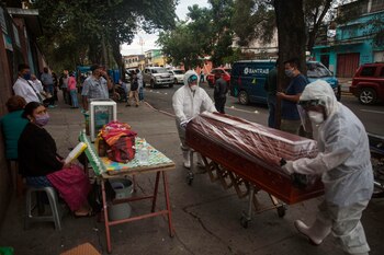 Trabajadores de una funeraria transportan el 28 de mayo de 2020 el féretro de una mujer de 75 años fallecida por coronavirus, desde el Hospital General San Juan de Dios hacia el cementerio, en Ciudad de Guatemala (Guatemala). EFE/Esteban Biba