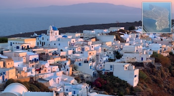 Pueblo en ladera con casas blancas y detalles azules, iglesia de cúpulas azules, mar, montañas y mapa aéreo de una isla.