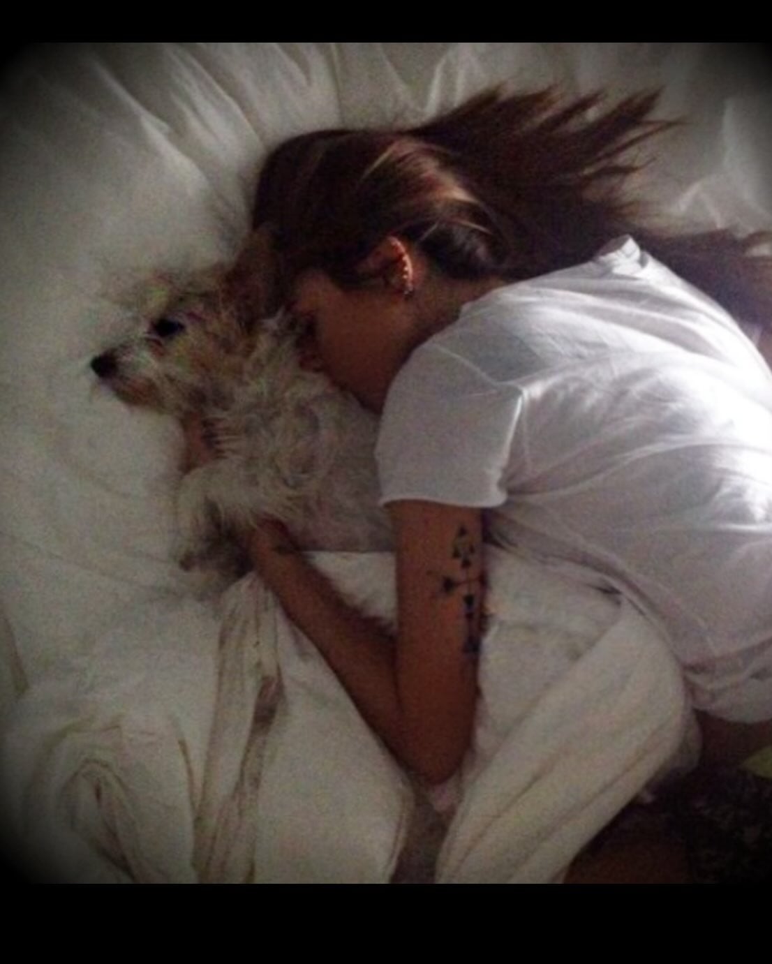 Cande Tinelli yace en una cama abrazada a su perra Linda.