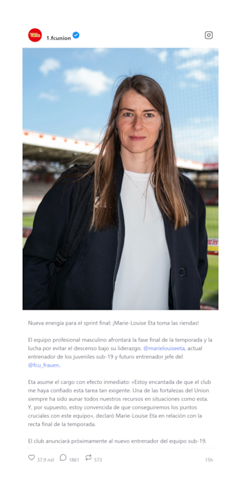 Retrato de Marie-Louise Eta, una mujer con cabello castaño largo, vistiendo chaqueta negra y camiseta blanca, mirando a la cámara en un estadio