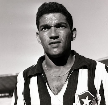 Fotografía en blanco y negro del futbolista Garrincha con la camiseta a rayas del Botafogo y una cadena fina en el cuello
