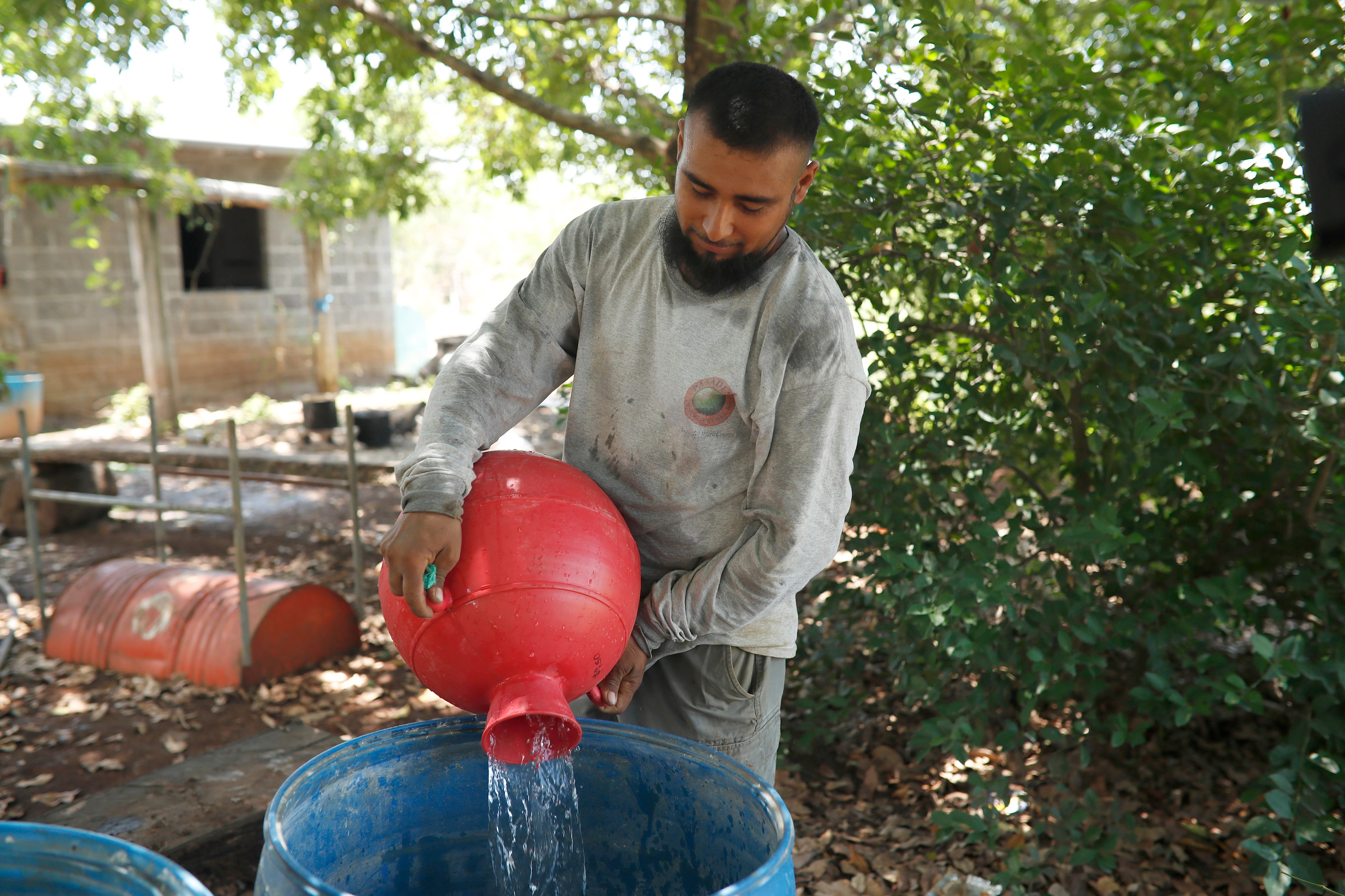 ACOMPAÑA CRÓNICA: EL SALVADOR AGUA AME1721. NUEVA CONCEPCIÓN (EL SALVADOR), 14/05/2026.- Un hombre utiliza cántaros y barriles para almacenar agua este martes, en Nueva Concepción (El Salvador). El sueño de contar con agua potable de miles de personas que viven en zonas rurales de El Salvador será cumplido en parte con la ayuda del papa León XIV, a través de una donación de 100.000 dólares para la instalación de sistemas de suministro y de plantas de tratamiento. EFE/Rodrigo Sura