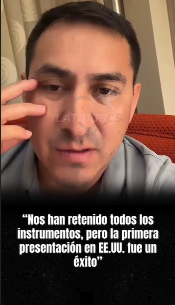 Primer plano de un hombre con polo azul claro y mano derecha cerca de su rostro, con texto blanco sobre fondo negro y un logotipo semitransparente