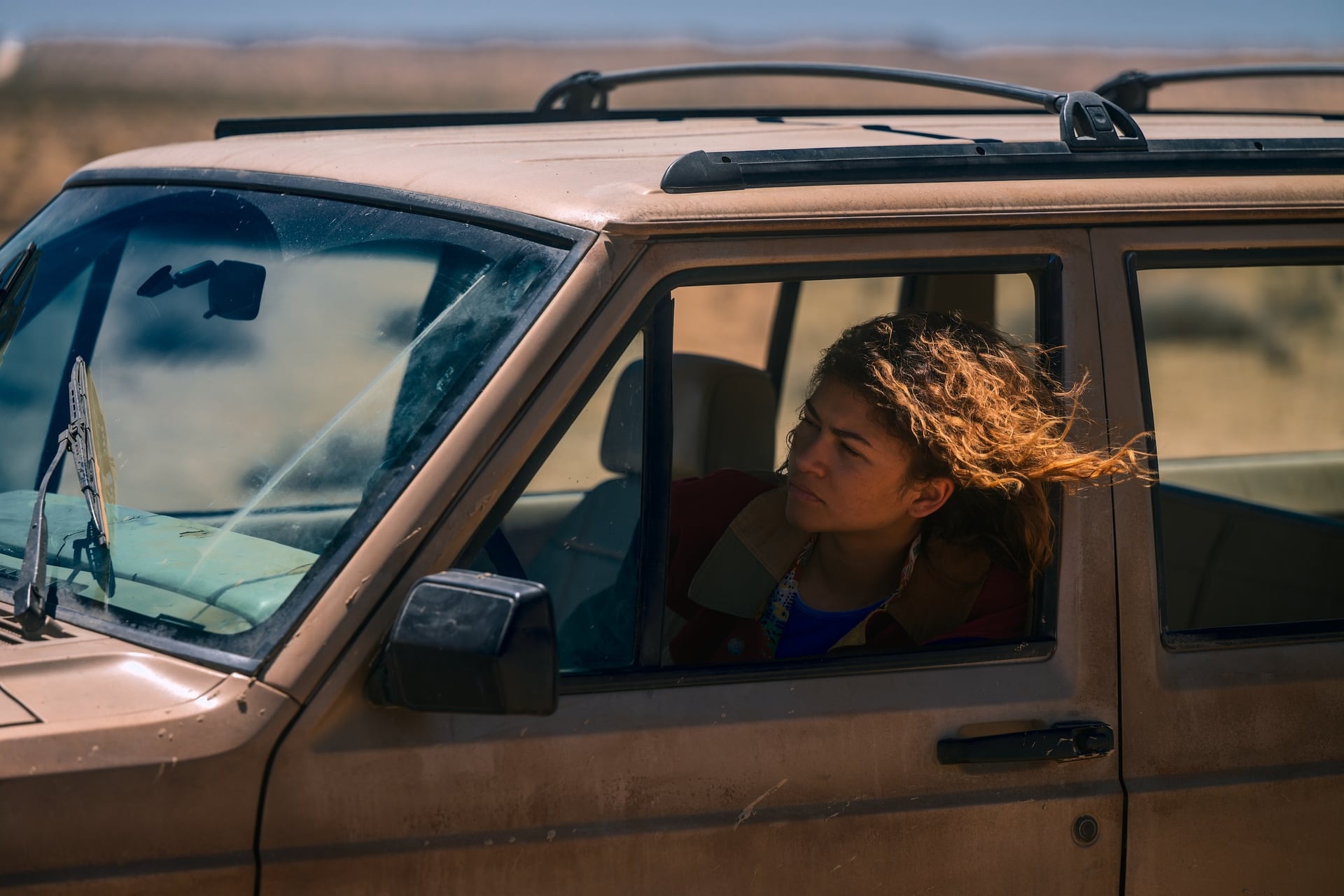 Rue Bennett, personaje de Euphoria, se asoma por la ventana de un coche en un paisaje desértico, reflejando un momento clave de su compleja narrativa bajo la dirección de Sam Levinson. (HBO Max)