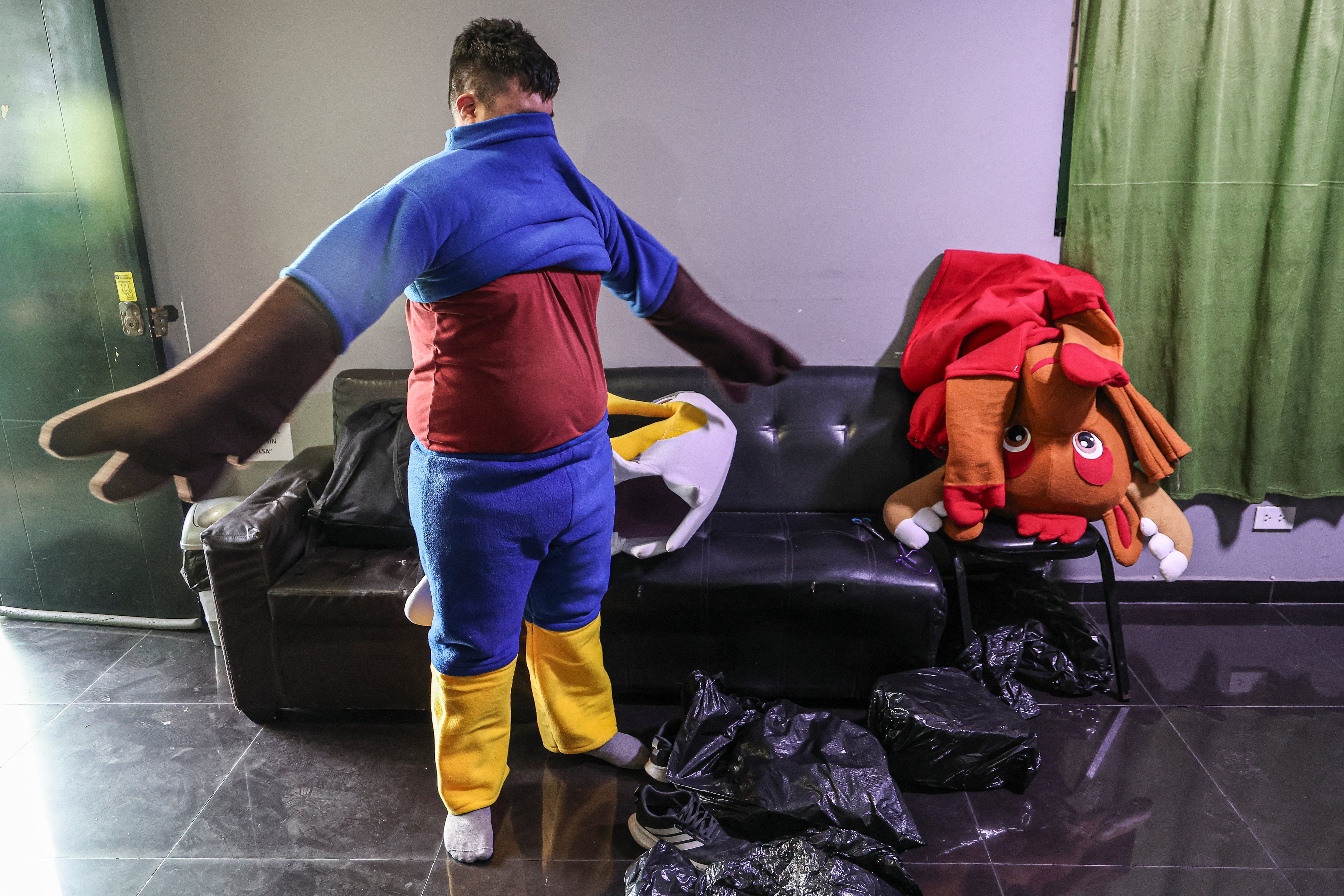 Un agente de la Policía de Perú se viste o desviste del disfraz de la mascota del Mundial 2026 durante una operación contra el narcotráfico en San Juan de Lurigancho. (AFP)