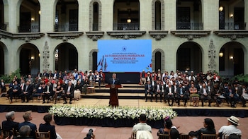 Un grupo de funcionarios y autoridades indígenas posan frente a una pantalla azul durante un acto oficial en Guatemala