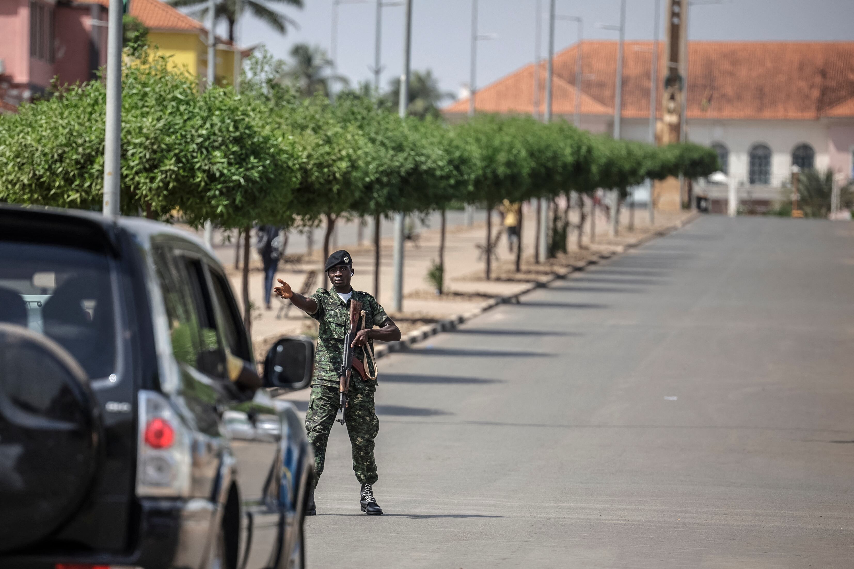 Un soldado detiene un vehículo cerca del Palacio Presidencial de Bissau, donde se escucharon disparos. (Patrick MEINHARDT / AFP)