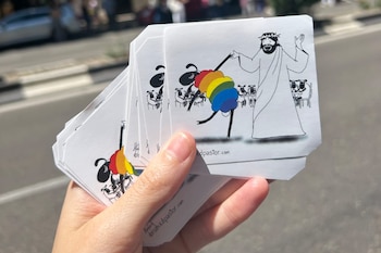 Pegatinas de una oveja LGTBI+ junto a Jesucristo que repartirá Águeda en la visita del papa León XIV en Madrid. (Imagen cedida)