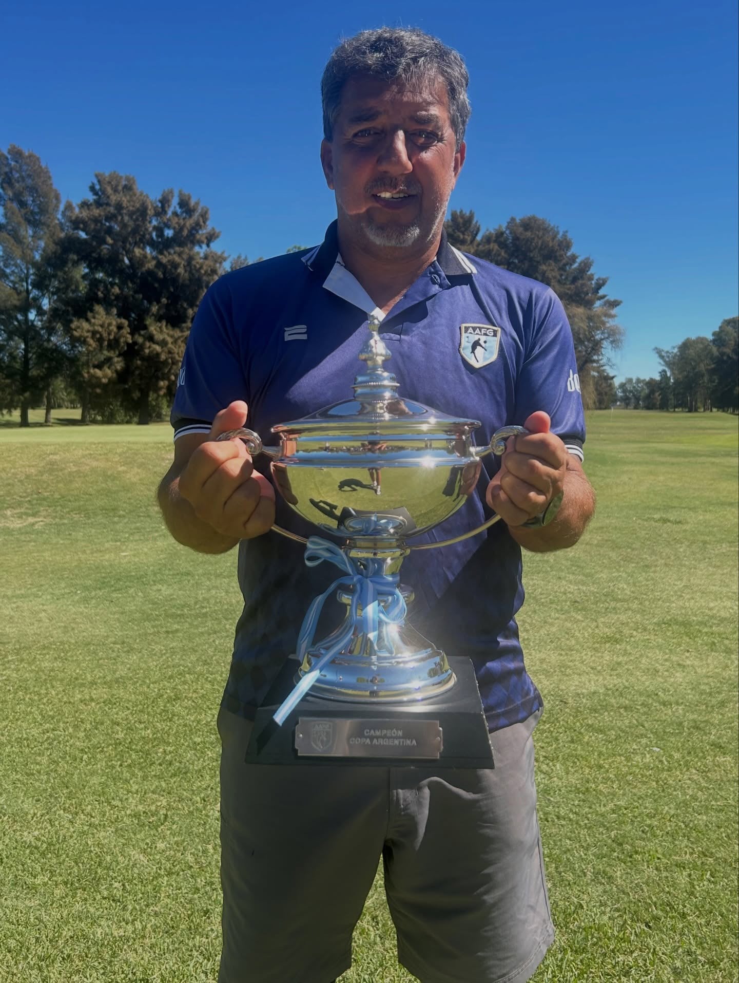El ex defensor de la selección argentina con un trofeo que ganó para el equipo argentino de footgolf