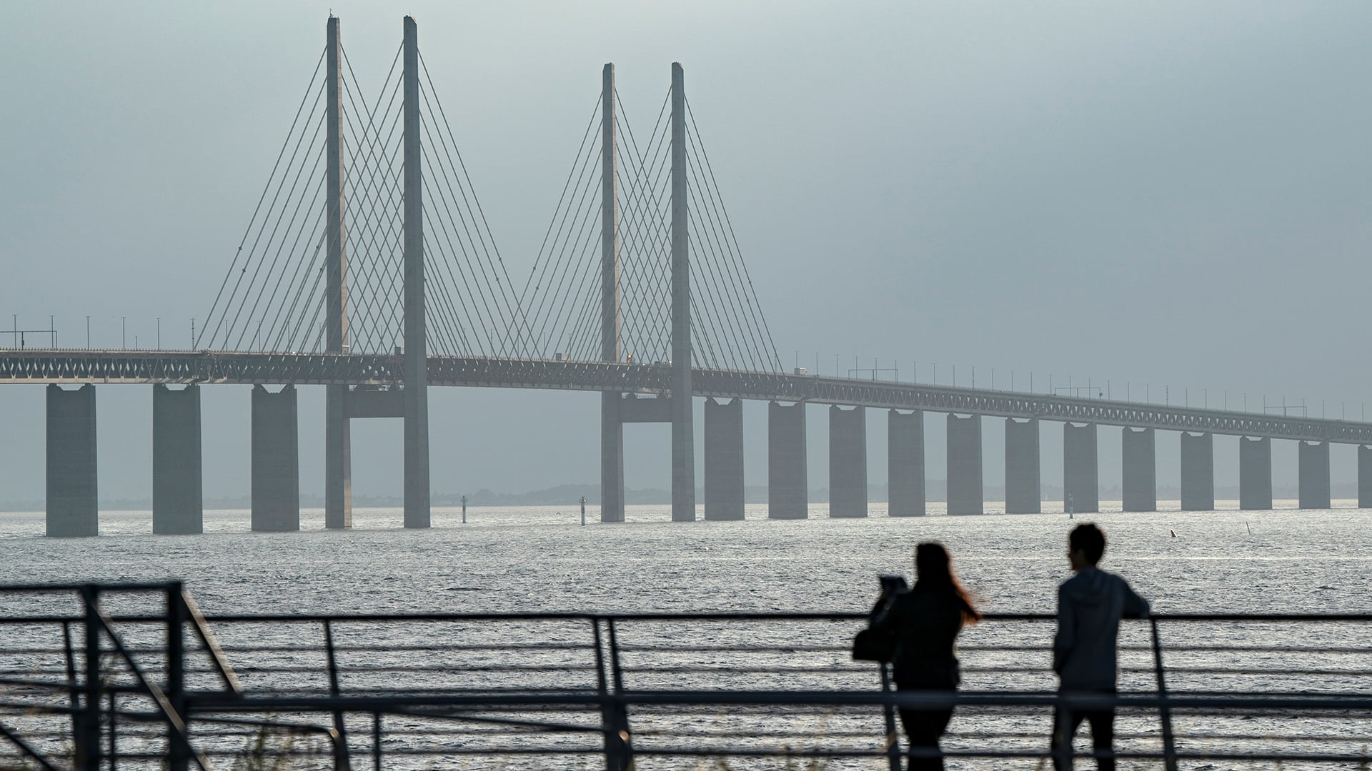 La gente disfruta de la puesta de sol y de la vista del puente de Oresund desde un mirador a las afueras de Malmö, Suecia, el 1 de julio de 2020
Johan Nilsson/TT News Agency/via REUTERS