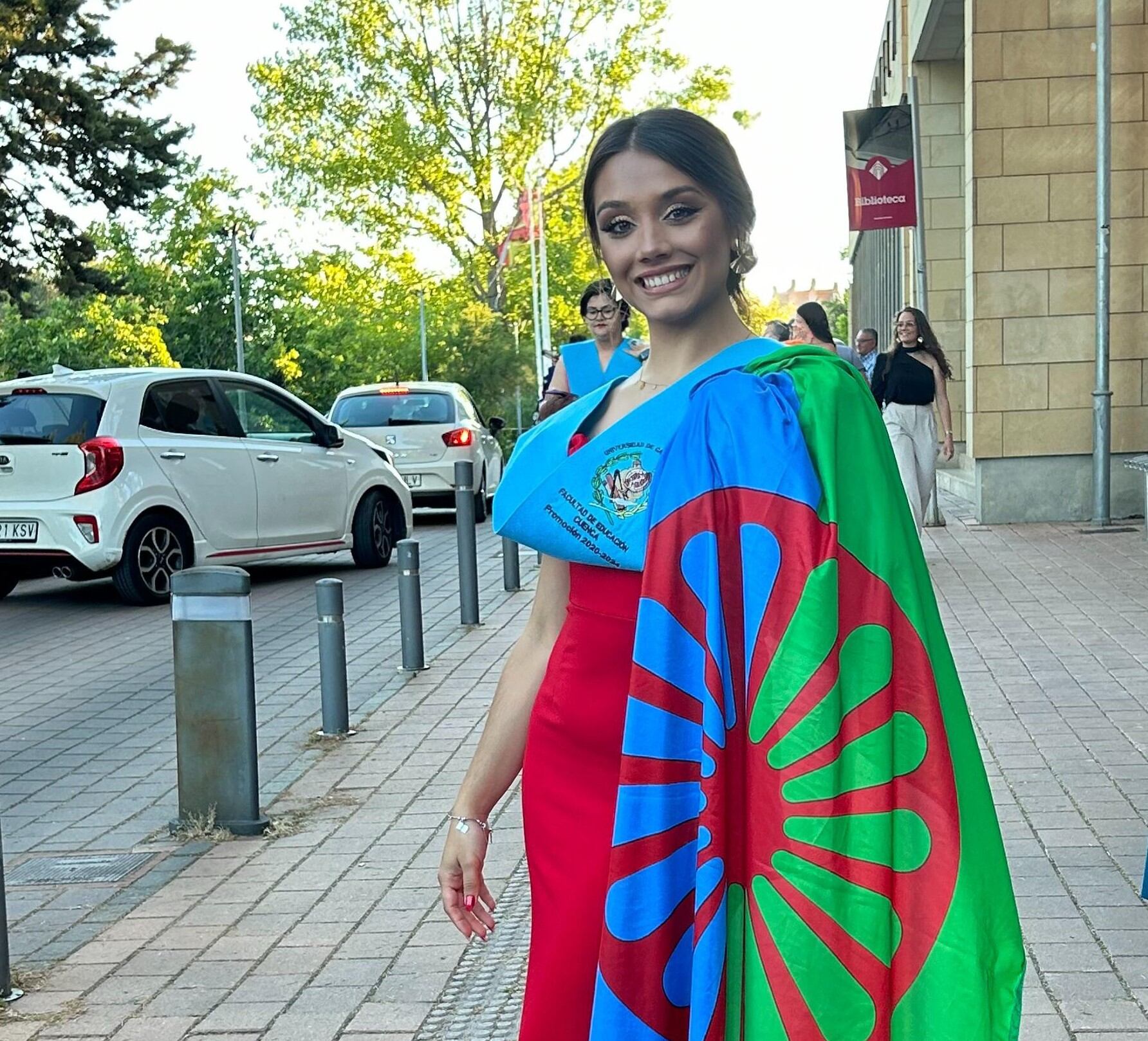 Carmen Jiménez junto a una bandera del pueblo gitano durante su graduación. (Cedida a Infobae)