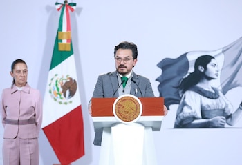Zoé Robledo habla en un podio con el escudo de México junto a Claudia Sheinbaum y la bandera nacional al fondo
