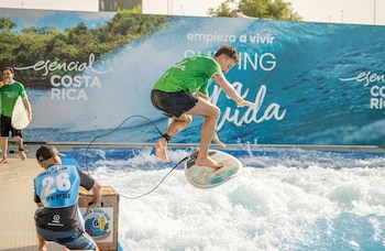 Visitantes experimentan el simulador de olas “Surfeando el Pura Vida” en Madrid, una iniciativa del Instituto Costarricense de Turismo. Crédito: ICT
