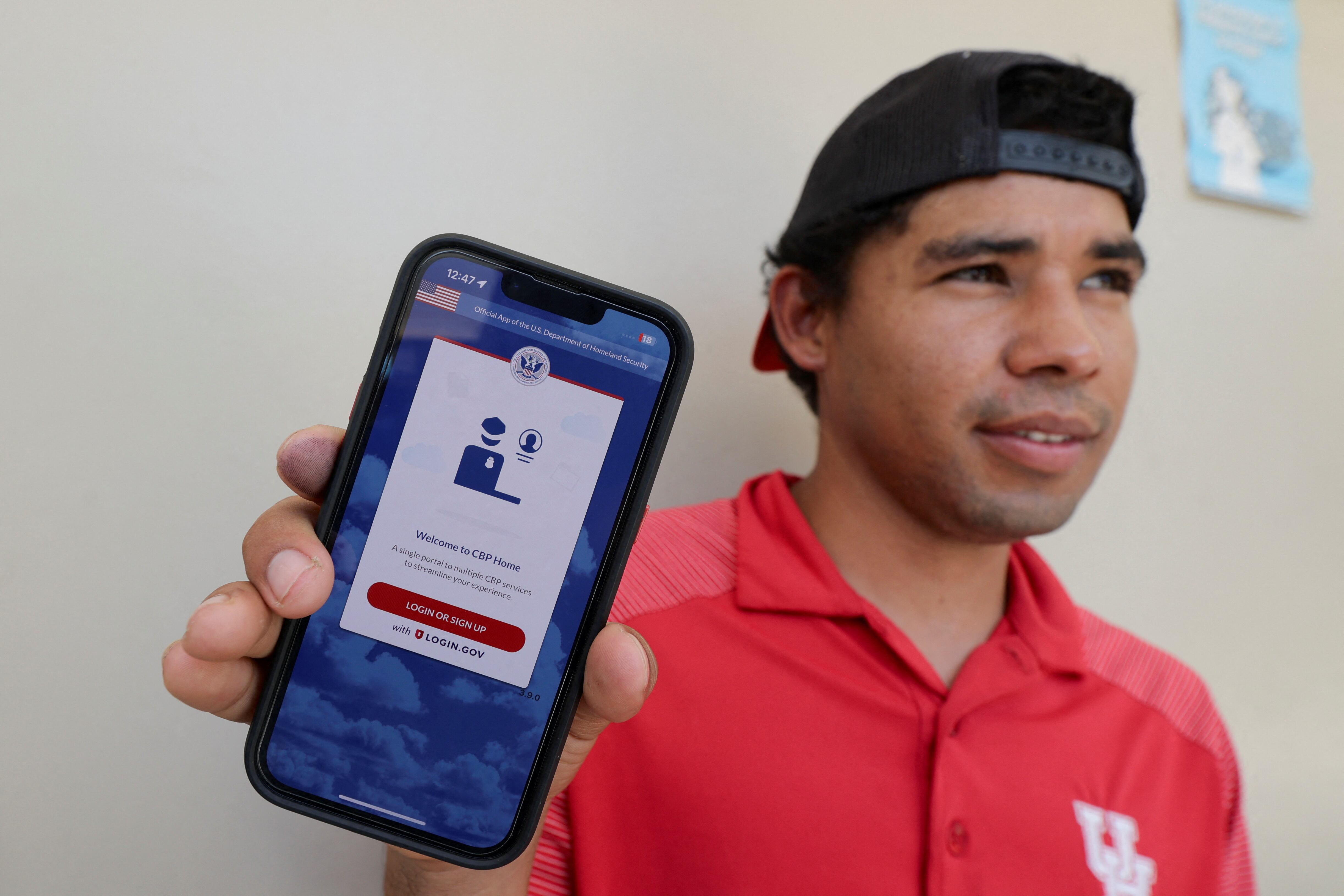 Un migrante hondureño muestra en su teléfono la aplicación CBP Home tras regresar a su país por vía voluntaria (REUTERS/Yoseph Amaya)
