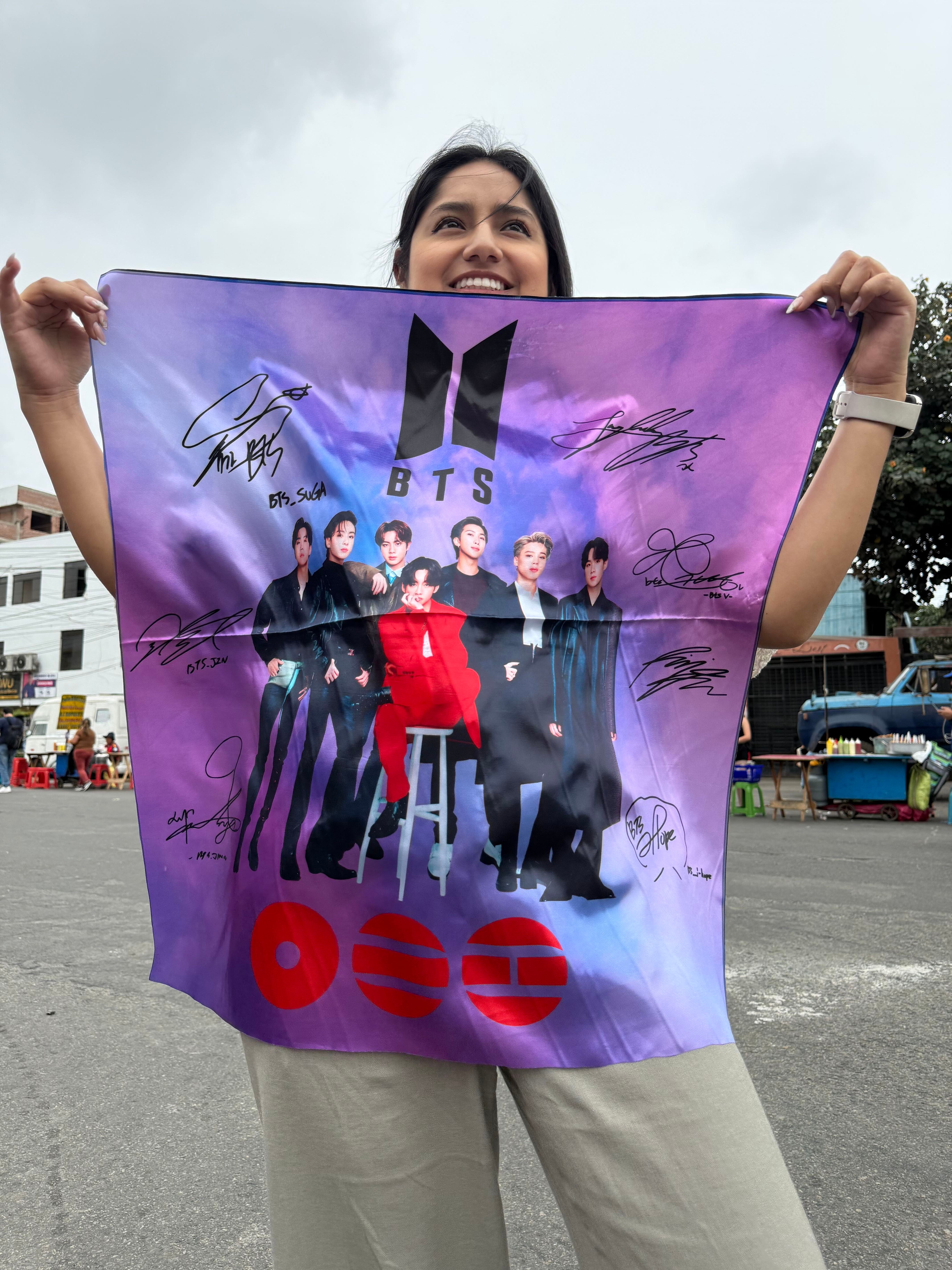 Una seguidora sostiene una tela con la imagen del grupo BTS en las afueras del Estadio San Marcos durante la venta de mercancía en Lima. (Paula Díaz)