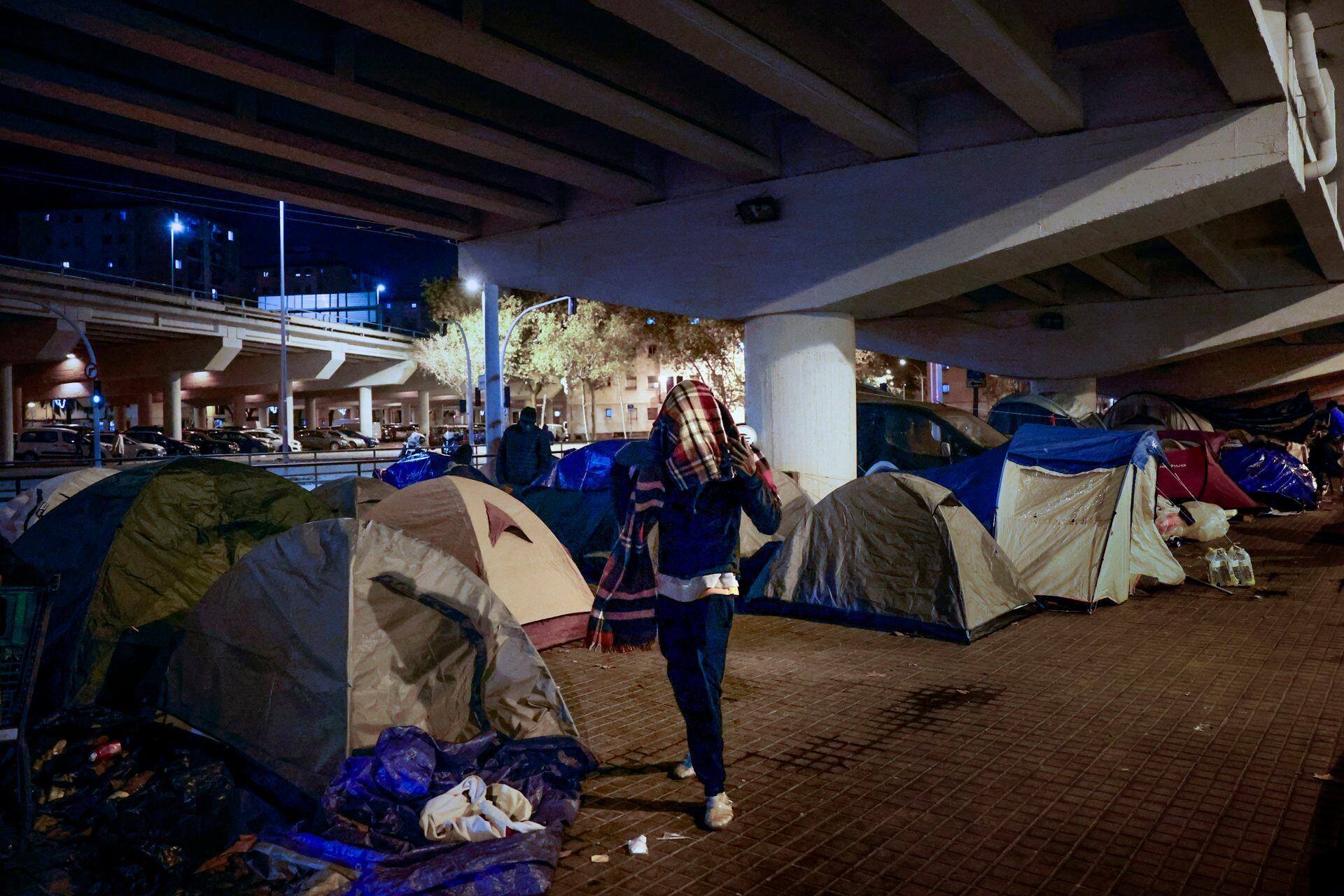 Unas 60 personas vulnerables desalojadas del antiguo instituto B9 de Badalona (Barcelona) pasan la Nochebuena bajo el puente de la autopista C31. (EFE/Alberto Estévez)