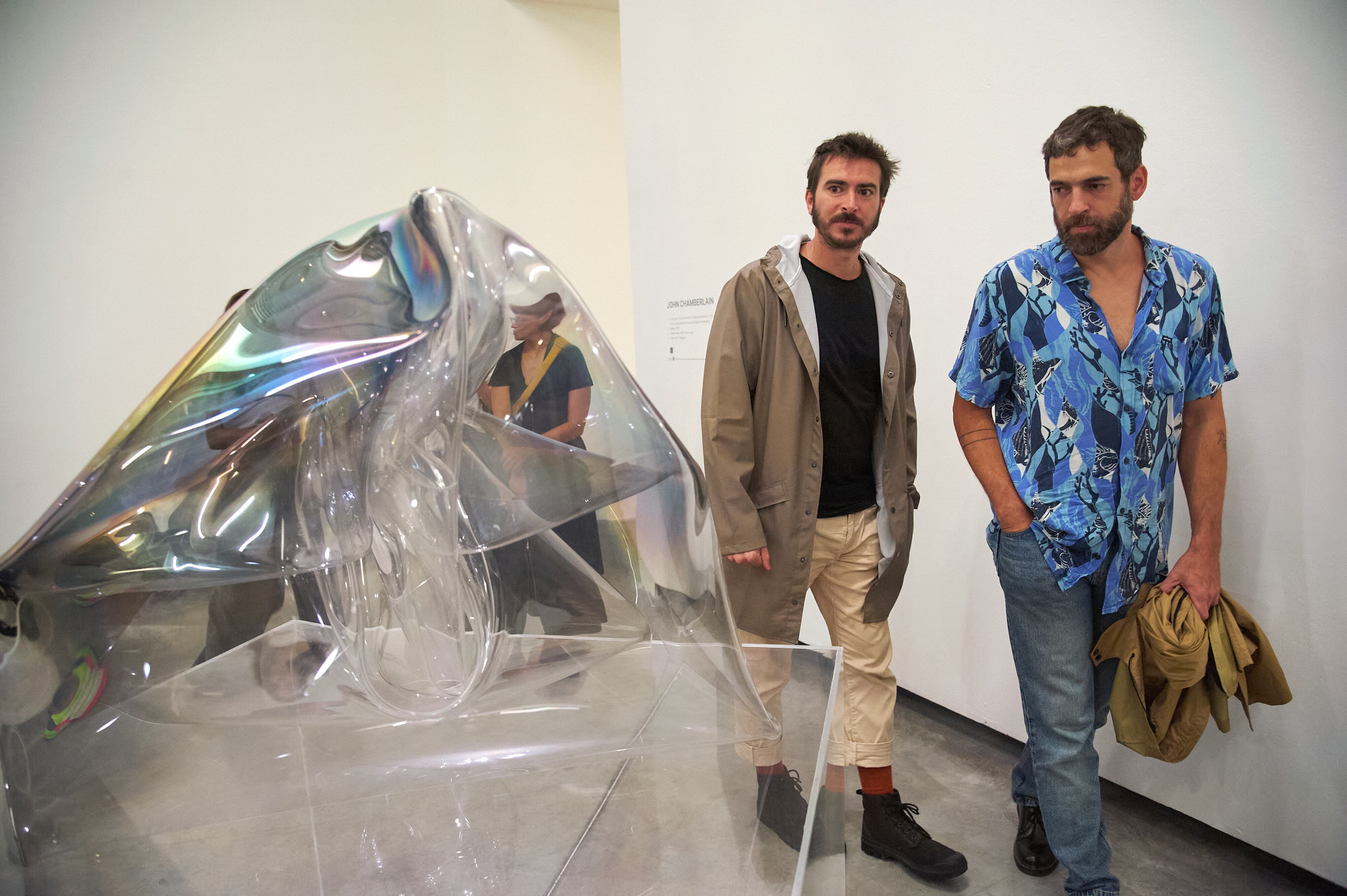 Visitantes observan una obra de John Chamberlain