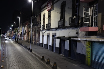 Vista nocturna de una calle adoquinada en el Centro Histórico de la CDMX con nuevas luminarias LED que iluminan edificios, balcones y comercios cerrados