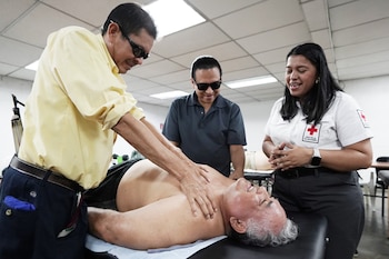 Durante una sesión práctica, los asistentes reciben instrucción en técnicas de masaje terapéutico como parte del proceso de formación.