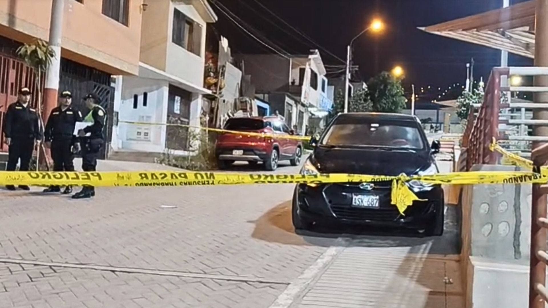 Agentes de la policía peruana aseguran la escena donde un hombre fue encontrado muerto a balazos dentro de su vehículo en Callao. (Exitosa)
