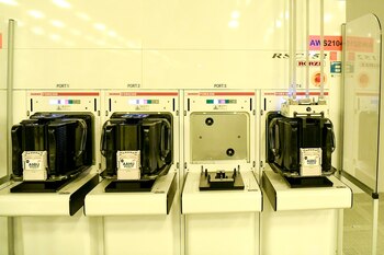 Los contenedores que contienen obleas de silicona impresas se estacionan en los puertos hasta que se transportan a otra área en la sala limpia en GlobalFoundries Fab 8. CRÉDITO: Foto para The Washington Post por Cindy Schultz