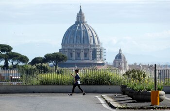Una mujer camina frente a la basílica de San Pedro en Roma (REUTERS/Remo Casilli)