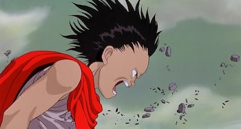Dibujo animado de un joven con cabello negro en puntas y capa roja que grita rodeado de piedras flotantes