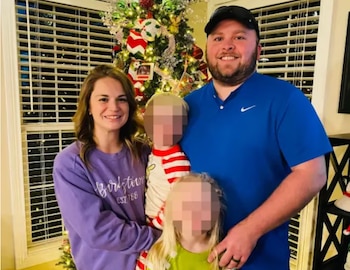 Una mujer, un hombre y dos niños pequeños posan frente a un árbol de Navidad verde y decorado con luces y adornos coloridos en un interior