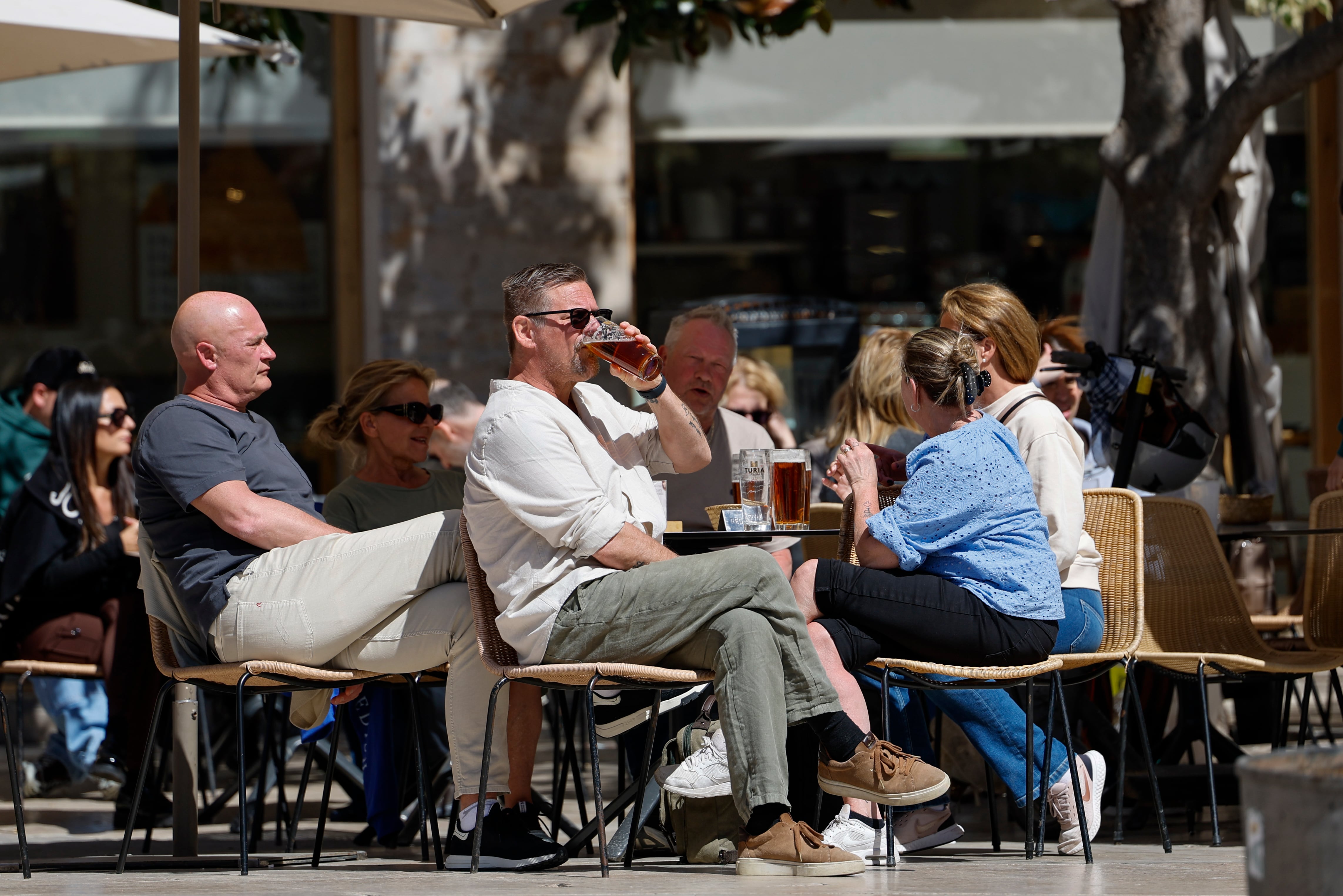 Unos turistas disfrutan del buen tiempo en una céntrica terraza de Valencia. (Ana Escobar/EFE)