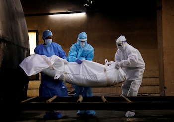 FILE PHOTO: A health worker and relatives wearing personal protective equipment (PPE) carry the body of a man, who died due to the coronavirus disease (COVID-19), for his cremation, at a crematorium in New Delhi, India August 17, 2020. REUTERS/Adnan Abidi/File Photo
