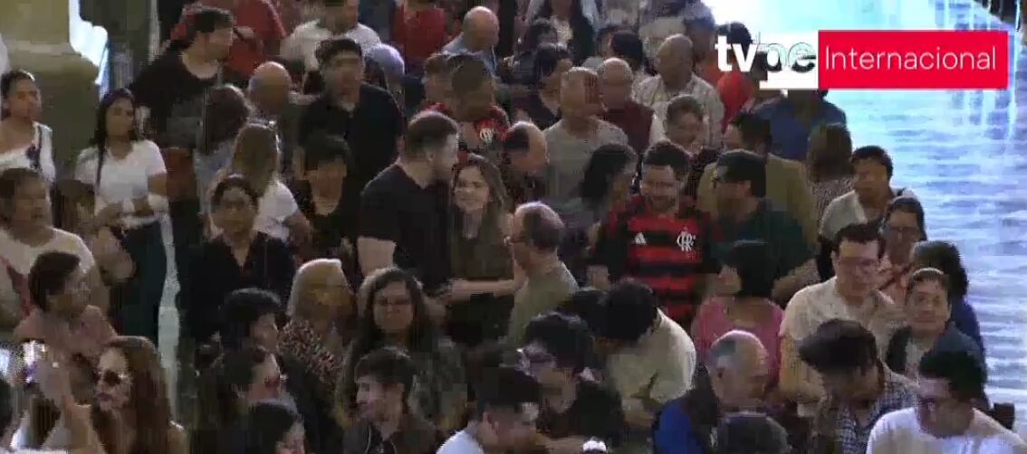 Hinchas del Flamengo dando la paz en misa. Foto captura: TV Perú.