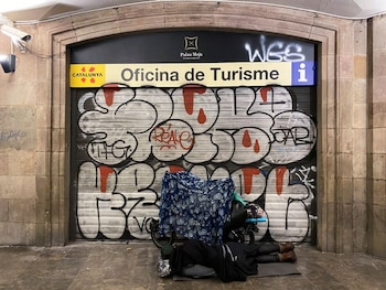 Una persona sin hogar duerme a la entrada de una oficina de turismo cerrada en Barcelona, España, el 22 de octubre de 2020. REUTERS/Nacho Doce