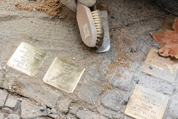 FILE — The artist Gunter Demnig places plaques called “Stolpersteine,” or “stumbling stones” at the entrance to a building in Berlin, Nov. 14, 2015. Councilors in the eastern German town of Heidenau in September 2026 voted to stop installing memorial plaques outside homes of Holocaust victims, saying they would instead build a memorial at a cemetery. (Andreas Meichsner/The New York Times)