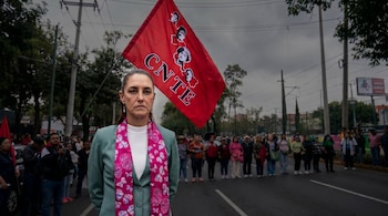 Retrato de Claudia Sheinbaum en primer plano, vestida de verde azulado y bufanda rosa, con una bandera roja de la CNTE y personas en un fondo difuminado.