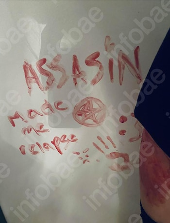 Mensaje en sangre sobre superficie blanca: 'ASSASSIN made me relapse!!!', un pentagrama, huellas de manos y manchas. Parte de un brazo con marcas rojas